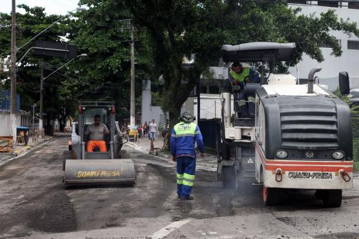 Homens e máquinas está fazendo pavimentação de rua. #Pracegover