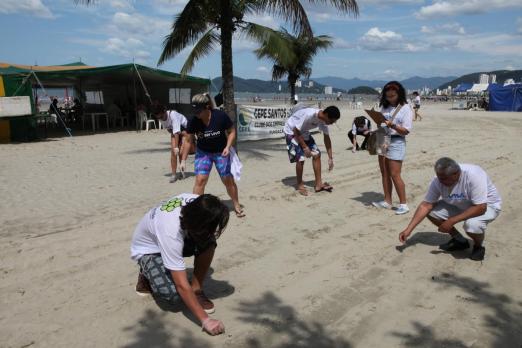 pessoas coletam lixo na praia #paratodosverem