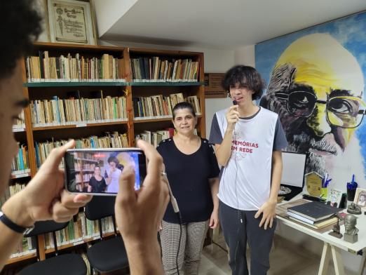 jovem faz entrevista enquanto outro filma com celular #paratodosverem 