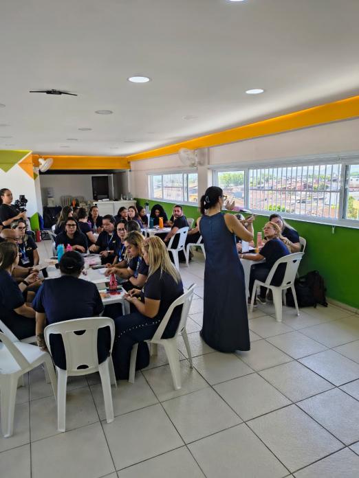 mulher faz apresentação a professores sentados #paratodosverem