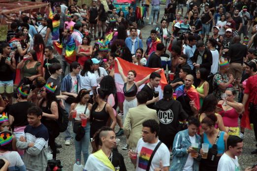 parada lgbt+ em rua, com pessoas fantasiadas se divertindo. #paratodosverem 
