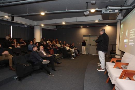 Pessoas no auditório acompanhando o evento #paratodosverem 