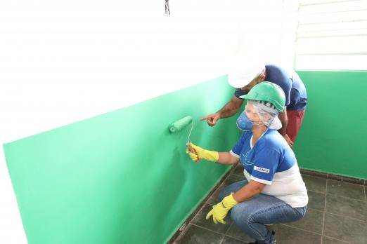 mulher pinta parede observada por professor #paratodosverem 