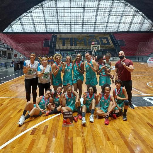 time de basquete posa para foto no ginásio #paratodosverem