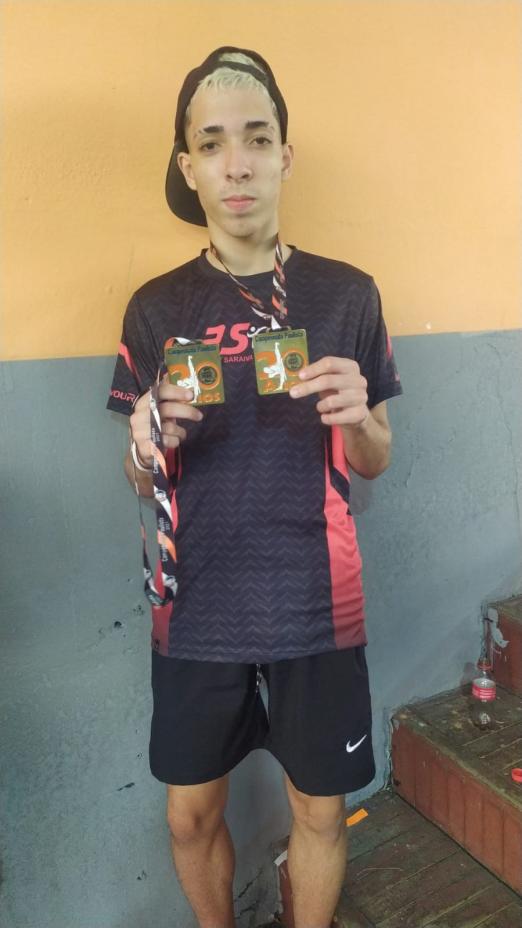 Atleta exibe duas medalhas #paratodosverem