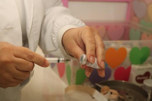 mãos preparam seringa para vacinação #paratodosverem