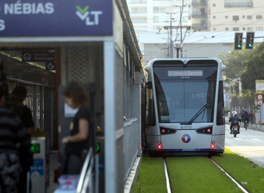 carro do VLT à direita,ao lado de estação com uma pessoa entrando. #paratodosverem