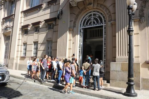 pessoas reunidas na frente de prédio histórico no walking tour #paratodosverem