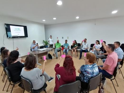 Pessoas estão reunidas em salão. Elas conversam. #Pracegover