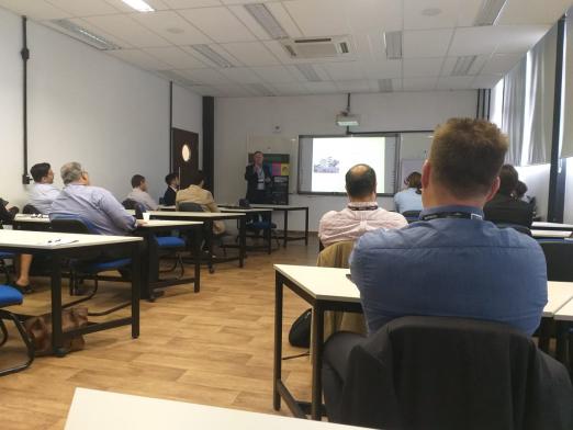 pessoas em sala de aula olham para telão #pracegover 