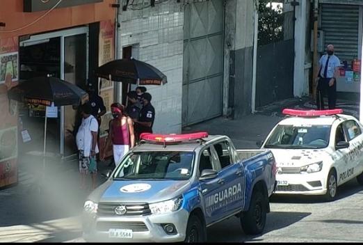 Viaturas da guarda e da polícia militar estão diante de estabelecimento. Há guardas também no local. #Paratodosverem