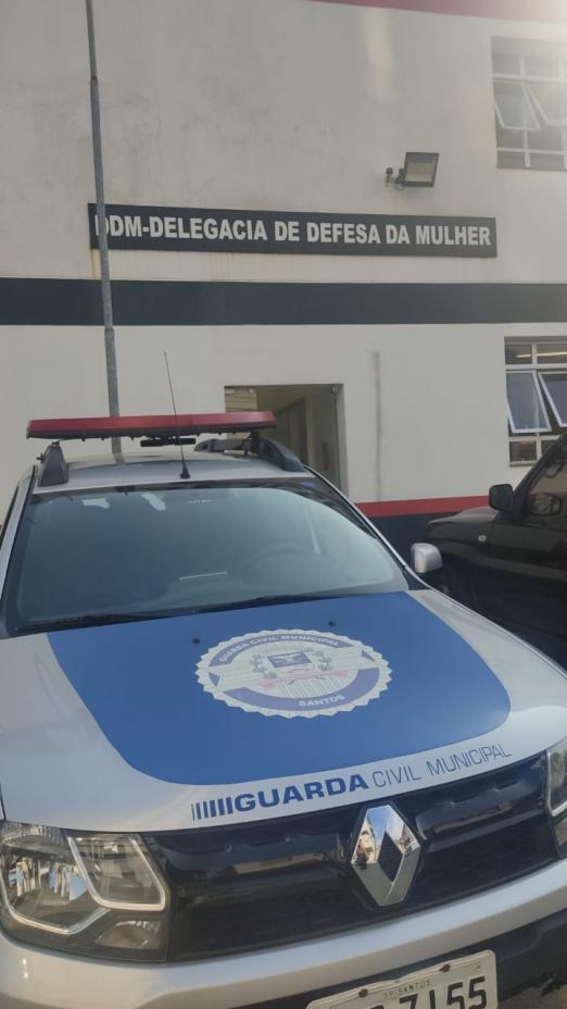 #pracegover Foto mostra carro da Guarda estacionado à frente da Delegacia da Mulher