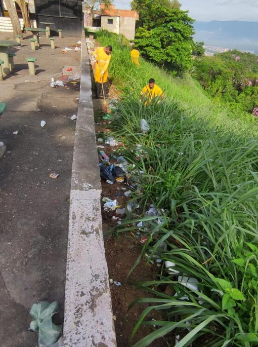 homens retiram lixo de encosta do morro com matagal #paratodosverem