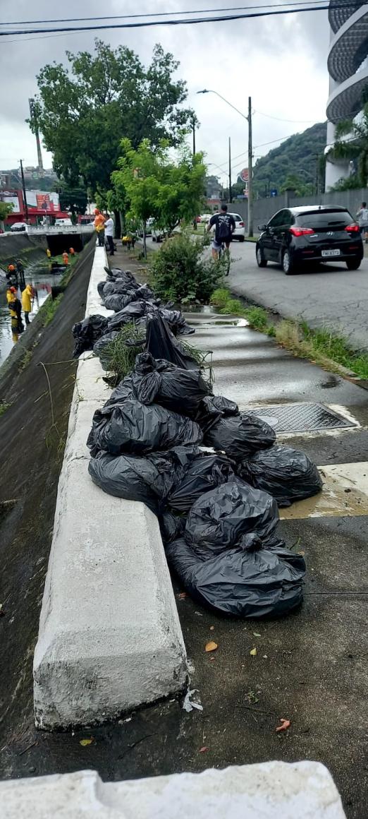 sacos de lixo amontados ao lado de canal #paratodosverem