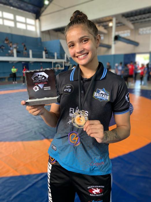 atleta exibe troféu e medalha #paratodosverem