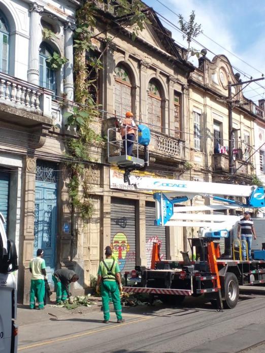 funcionarios fazem serviço em fachada de imóvel #paratodosverem