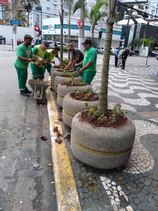 jardineiros trabalham nos vasos da praça #paratodosverem