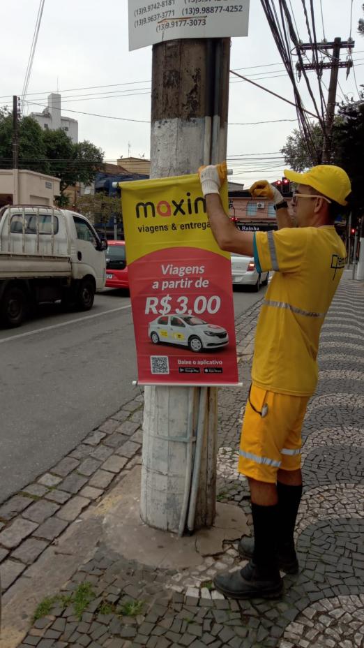 homem retira cartaz preso em poste #paratodosverem