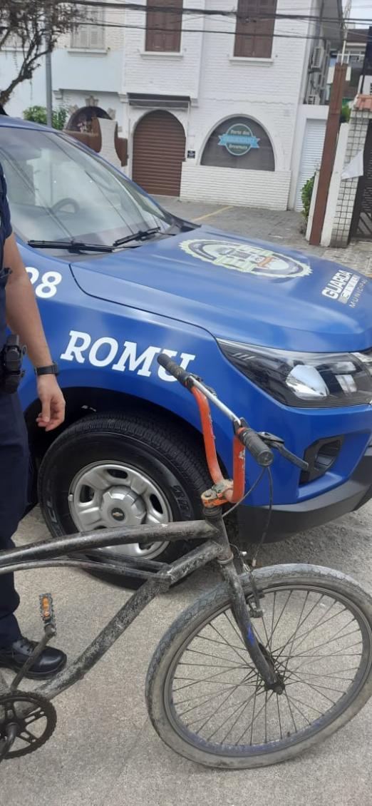 foto com a frente da bike aparecendo e uma viatura da guarda ao fundo. #paratodosverem