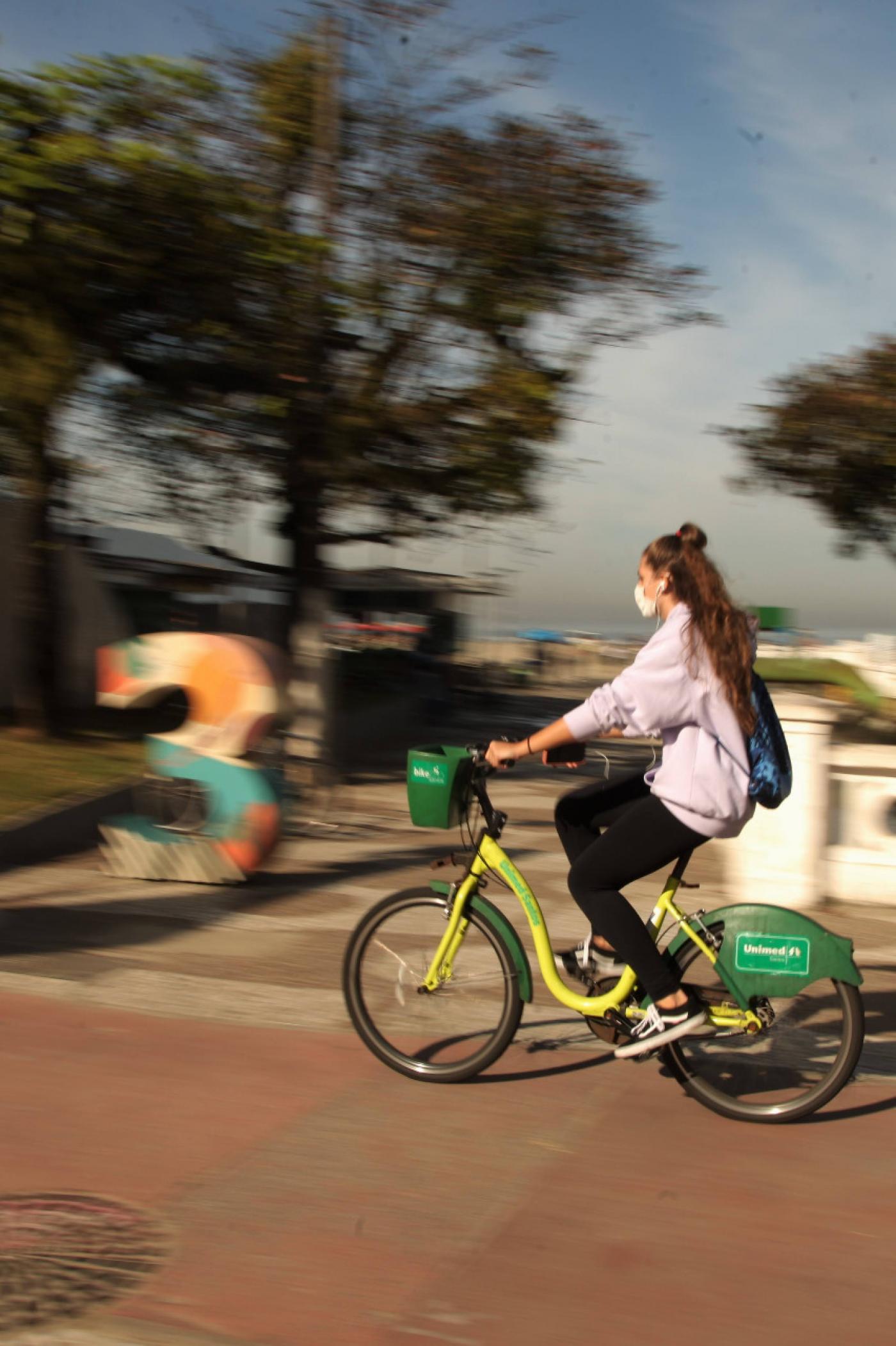 Mulher anda de bicicleta na ciclovia da orla de Santos. #paratodosverem