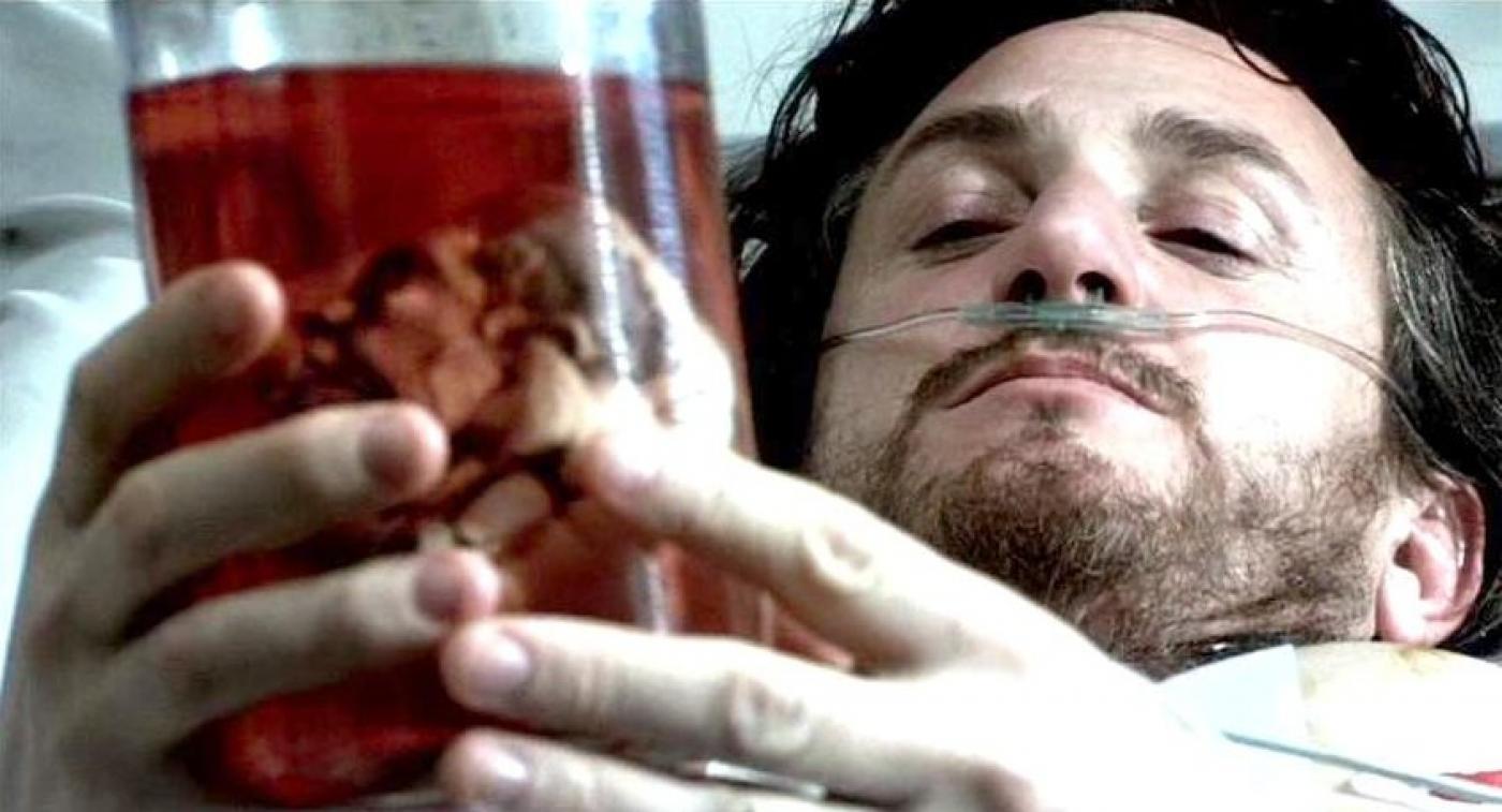em cena de filme 21 gramas, homem segura copo com órgão #pracegover  