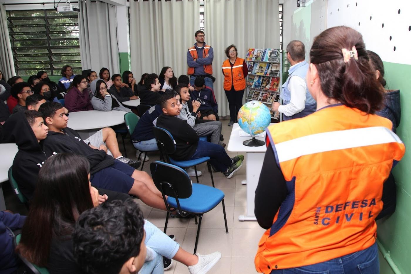 agentes da defesa civil estão em sala de aula com alunos. #paratodosverem