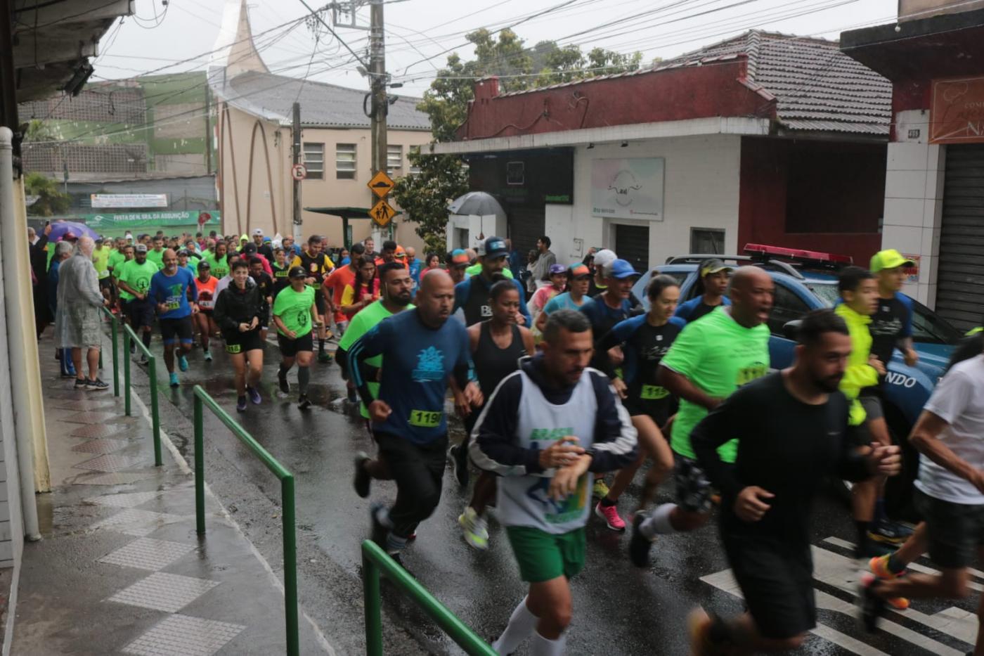 pessoas estão correndo em rua estreita de morro. #paratodosverem