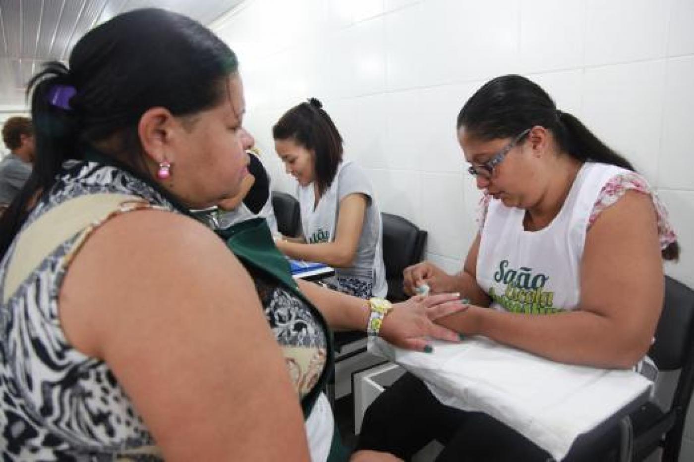 mulher faz a unha de cliente no salão #paratodosverem 