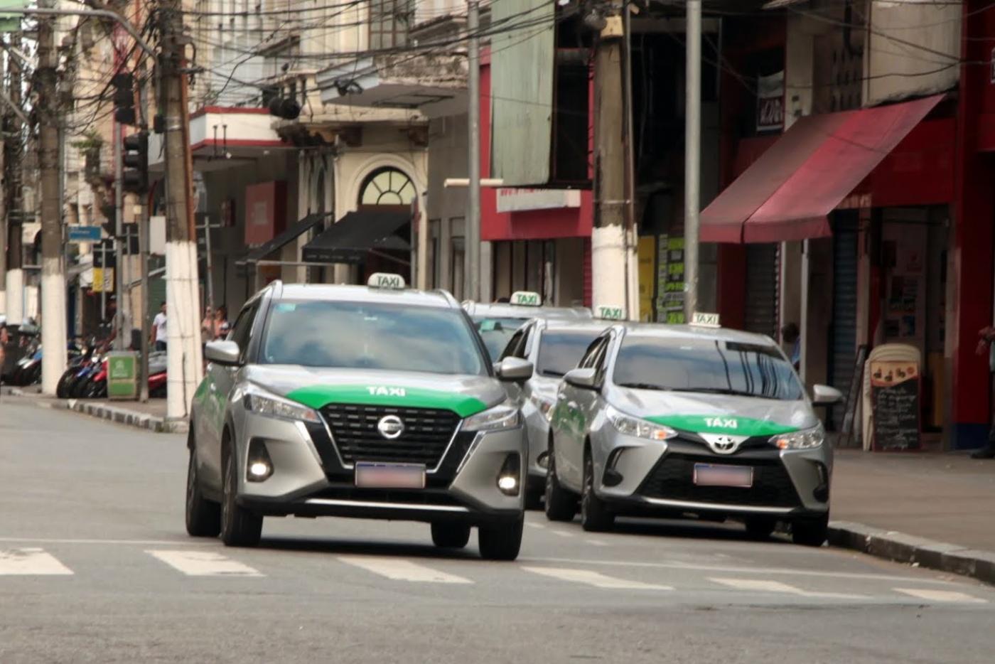 táxi rodando e outros estacionados. #paratodosverem 