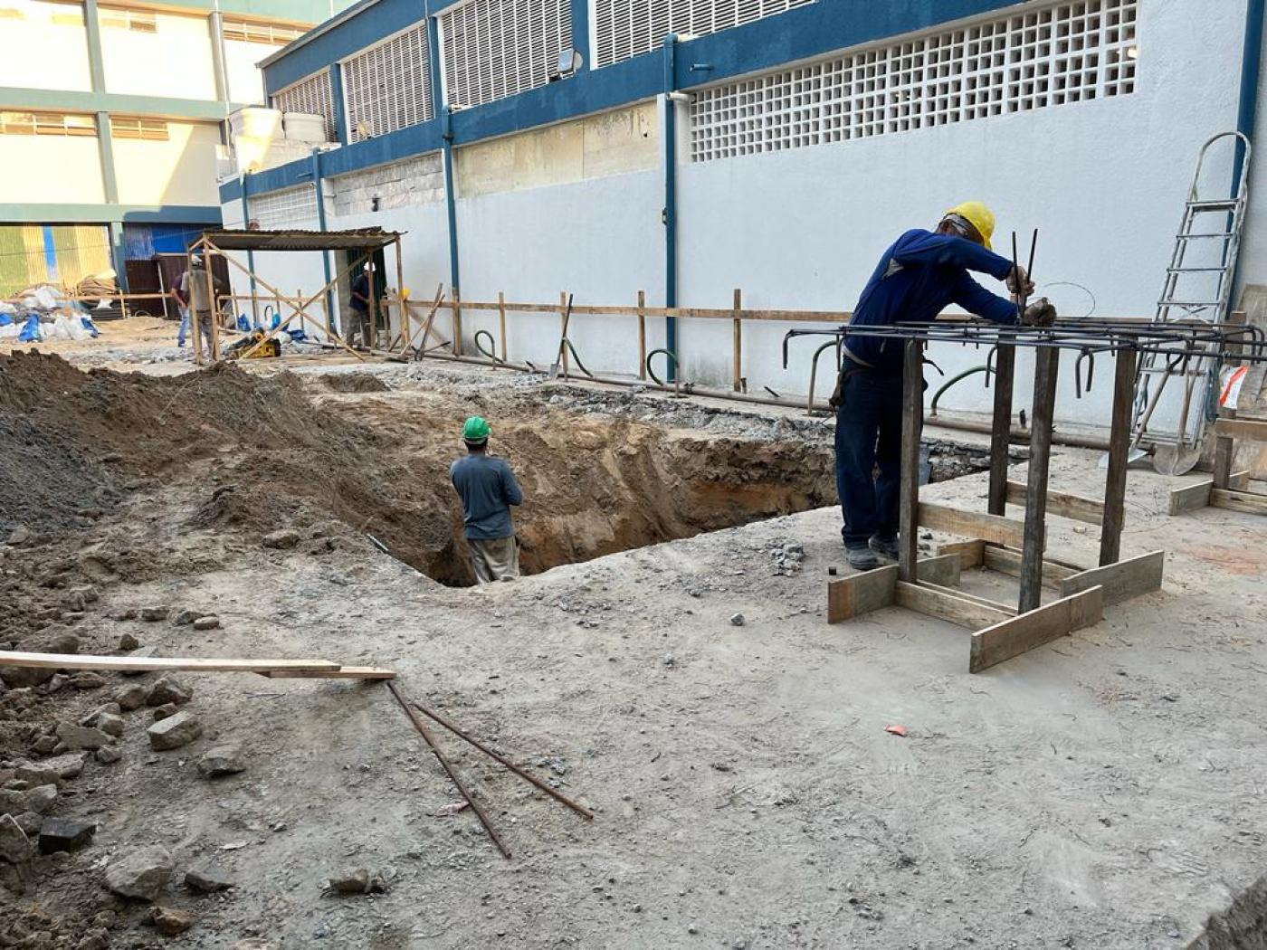 homens estão trabalhando na fundação de novo prédio. #paratodosverem 