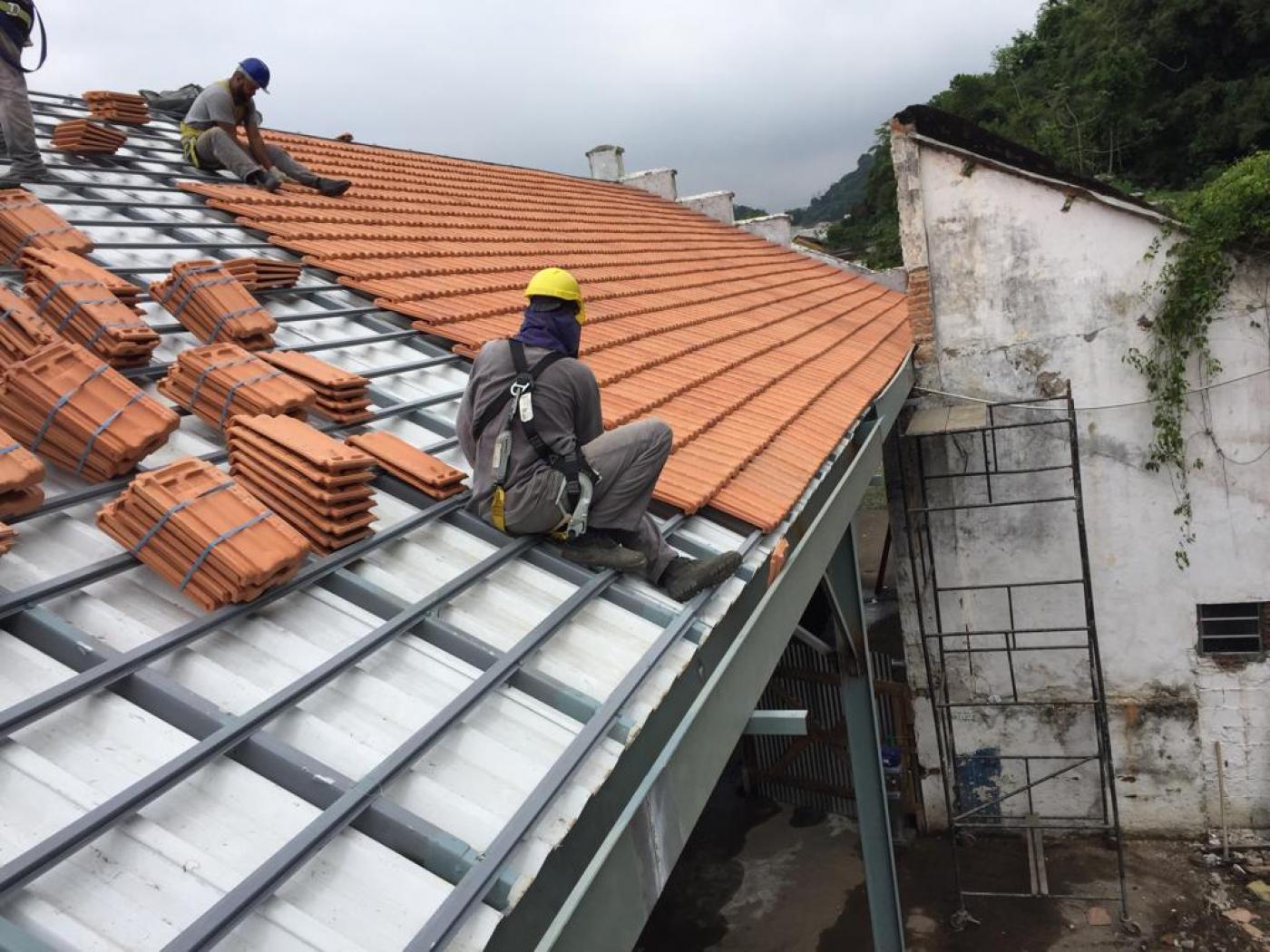 operário atua trocando telhas #paratodosverem 