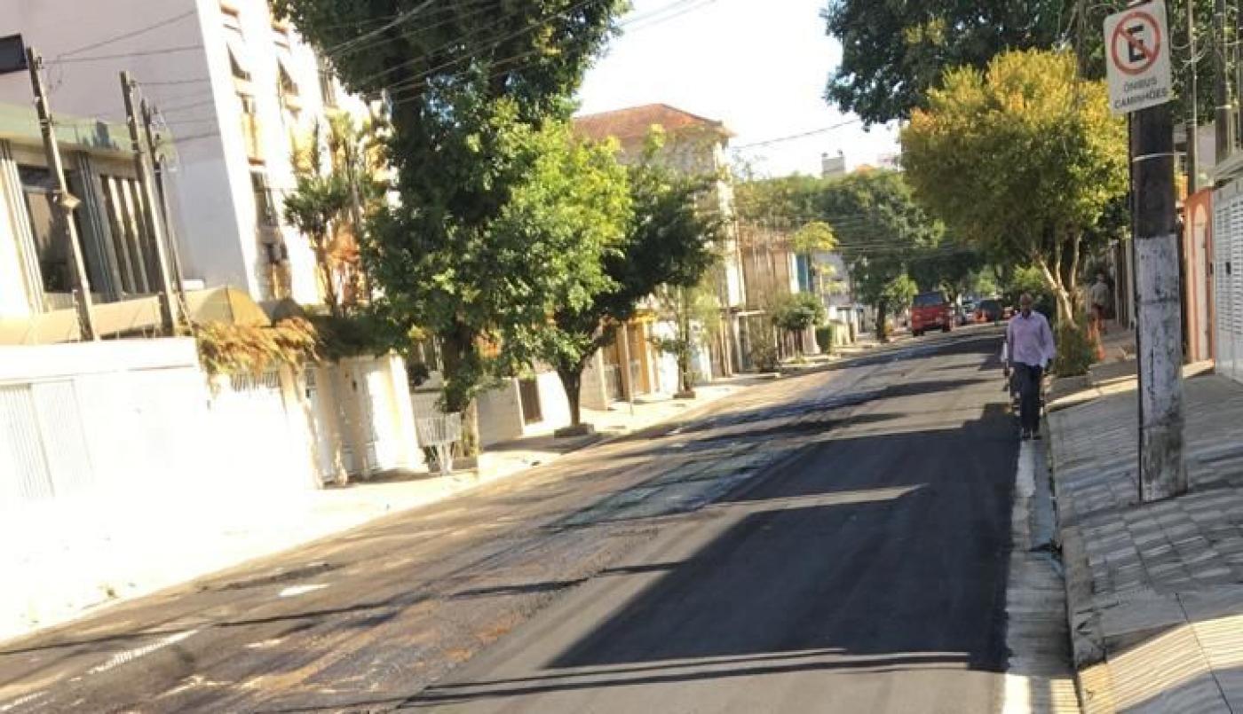 rua asfaltada com homem caminhando. #paratodosverem 