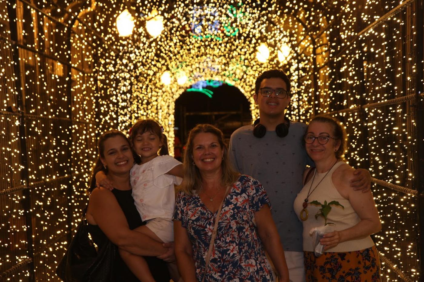 Família posa para foto em túnel iluminado #paratodosverem