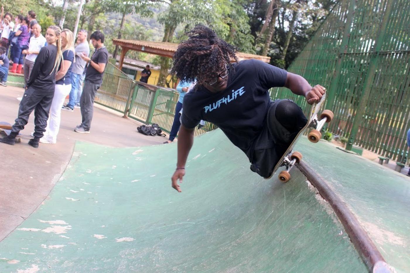 jovem com dificiência faz manobra de skate em rampa. #paratodosverem 