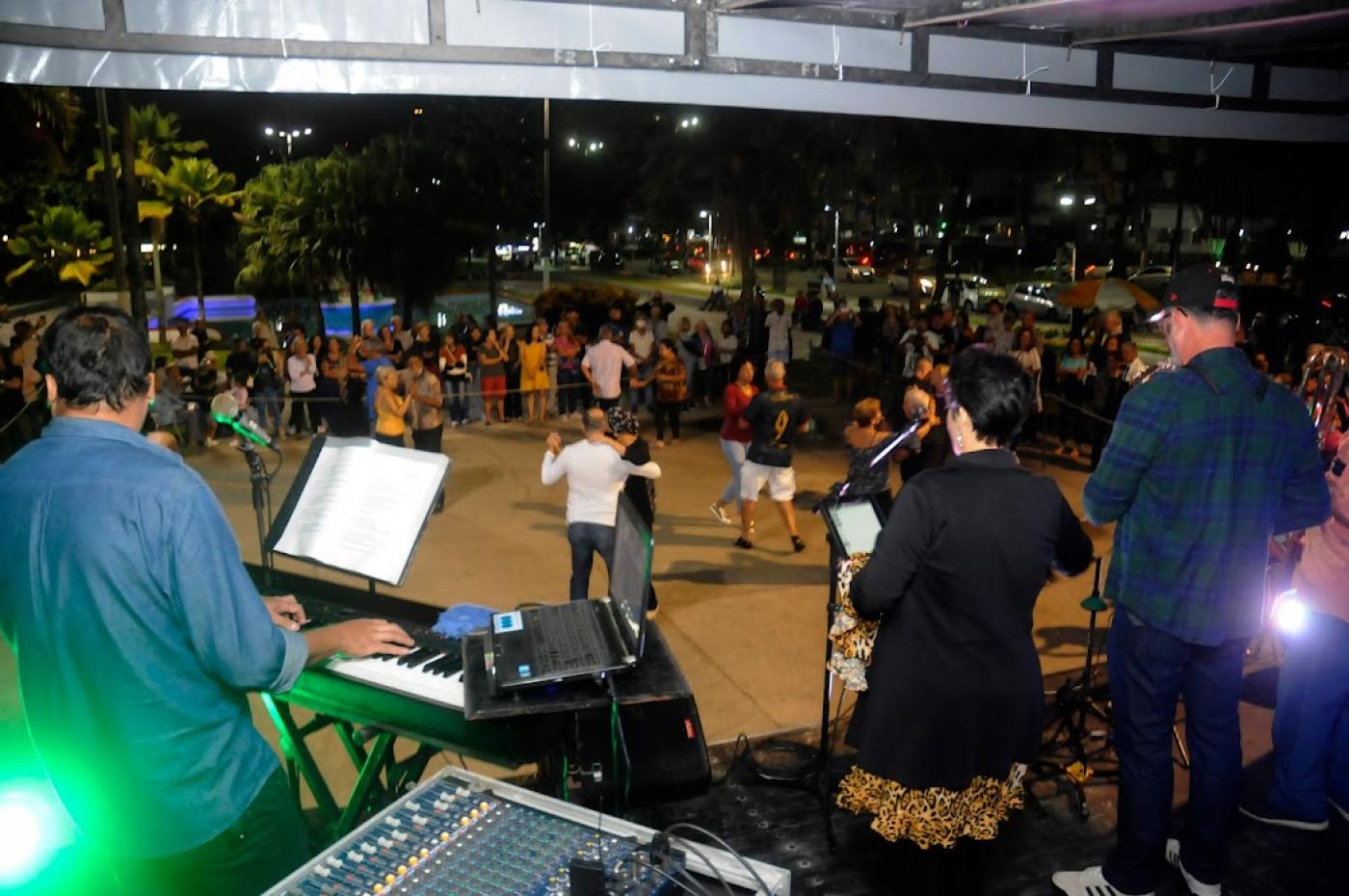 banda toca e pessoas dançando ao fundo #paratodosverem