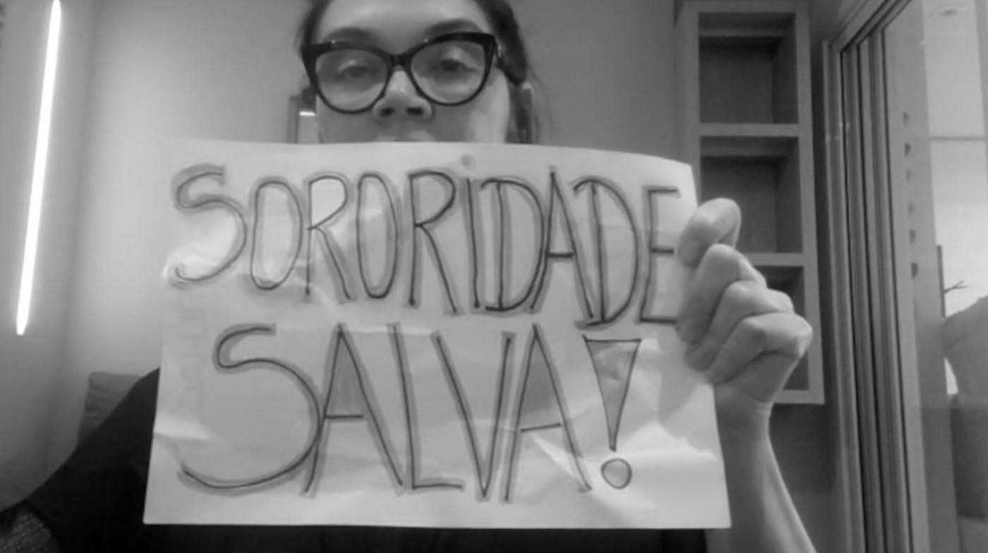 em trecho do vídeo, mulheer segura cartaz dizendo sororidade salva #paratodosverem 