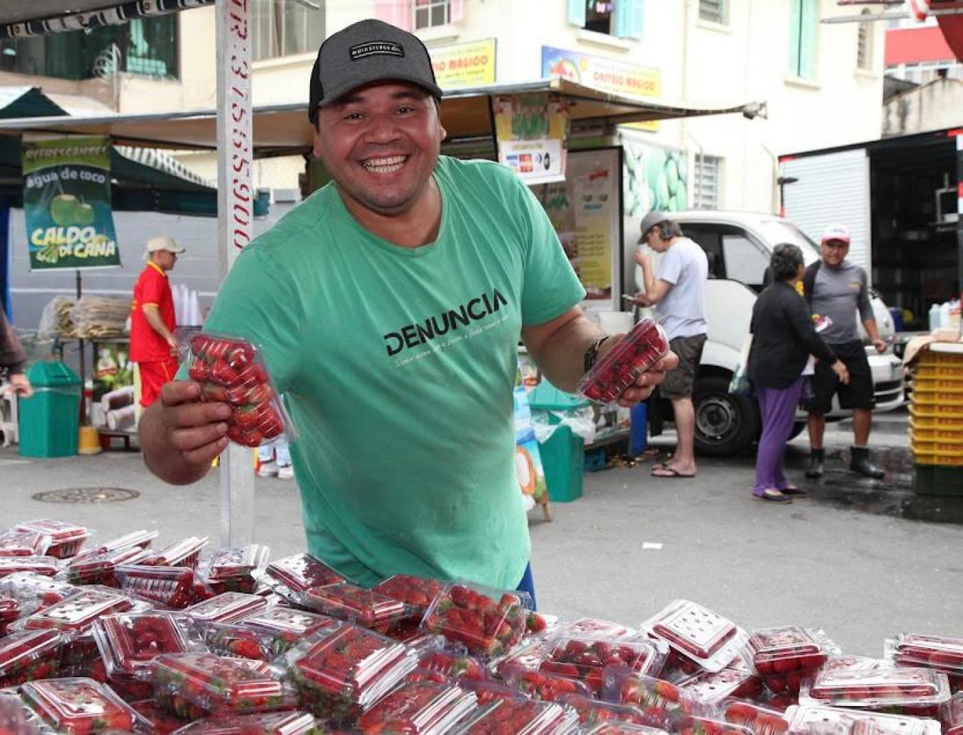 Abel sorri para foto segurando caixa de morangos. #paratodosverem