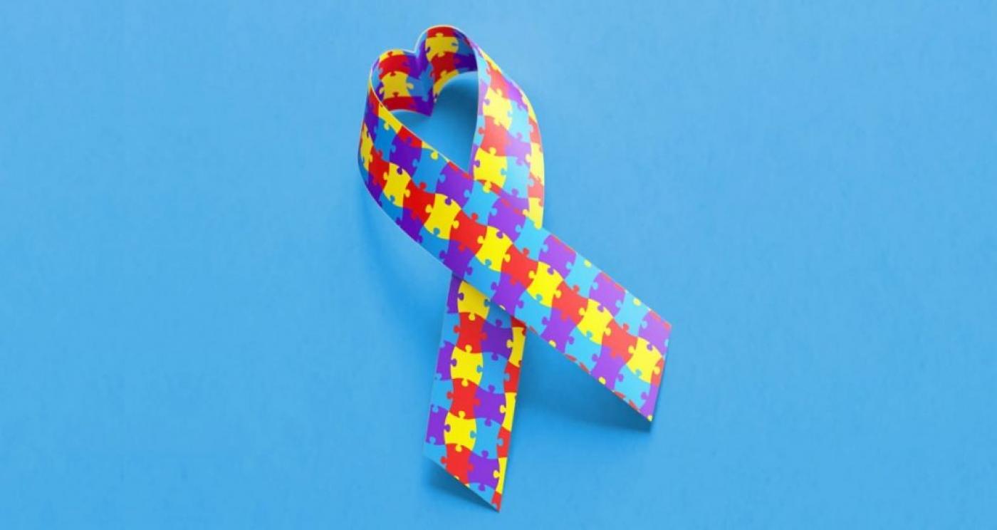fundo azul com fita colorida que simboliza o autismo. #paratodosverem