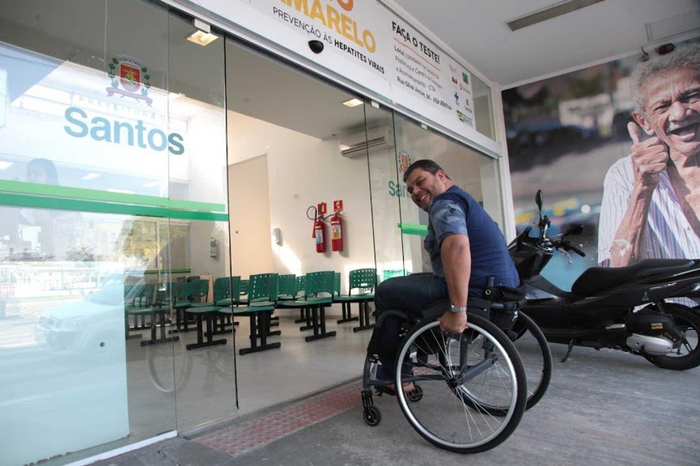 pessoa em cadeira de rodas chega em unidade de saúde #paratodosverem