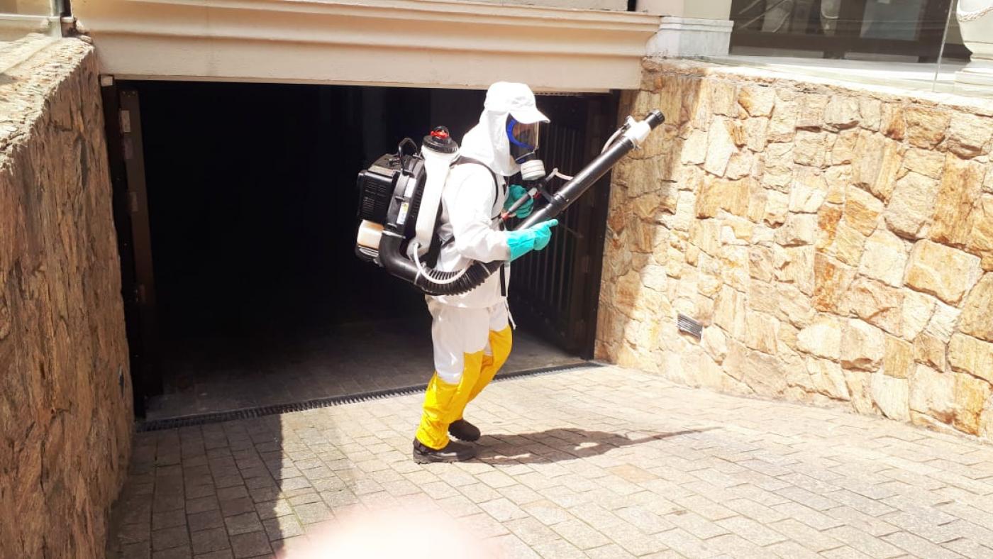 Homem com inseticida em rampa de garagem de prédio #paratodosverem