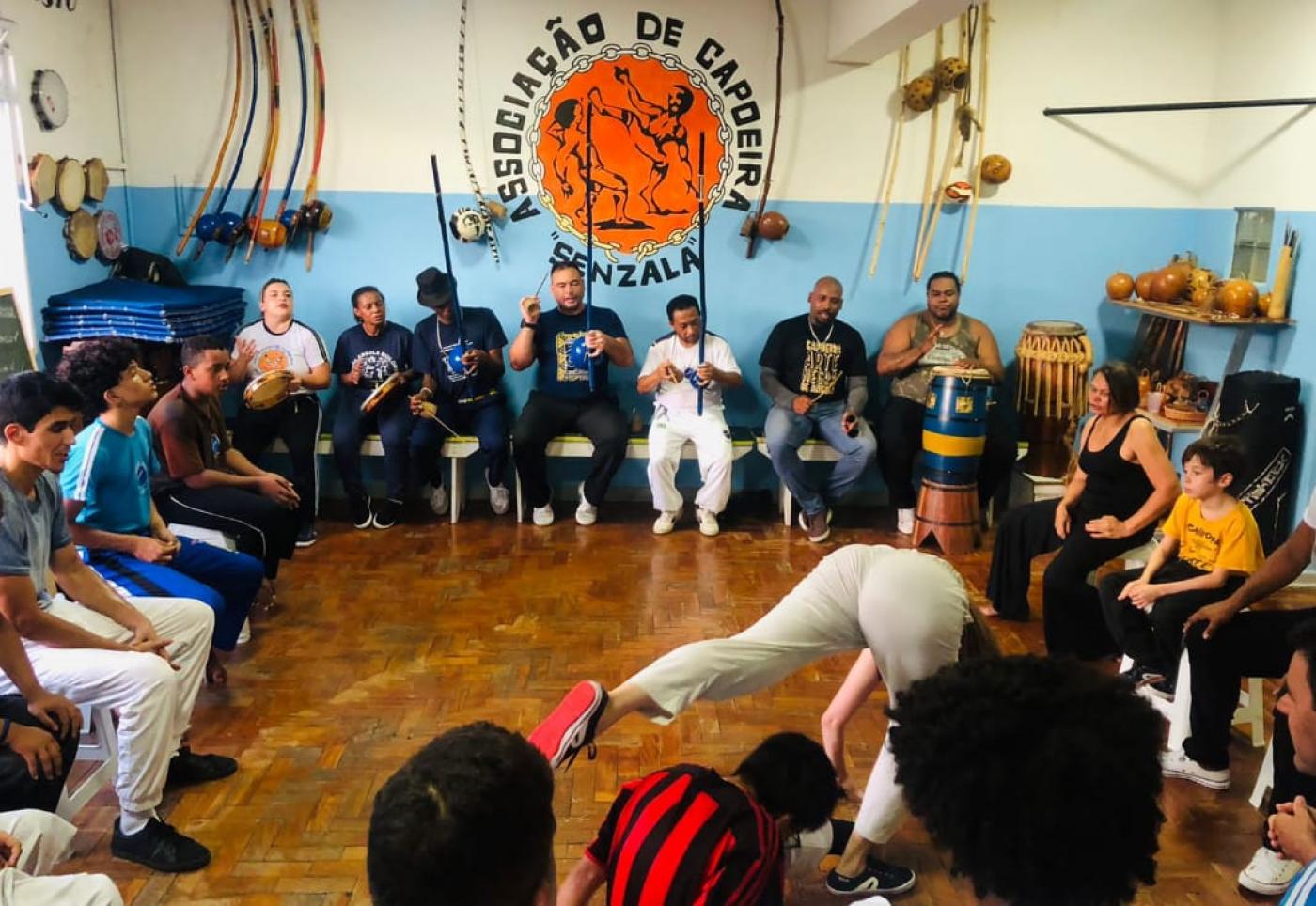 pessoas reunidas em roda com instrumentos musicais #paratodosverem