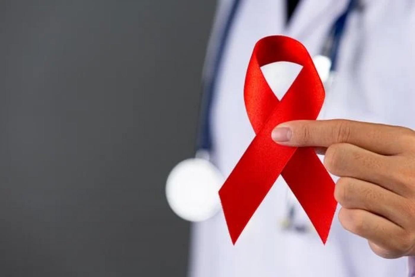 laço vermelho que representa a luta contra o HIV. #paratodosverem