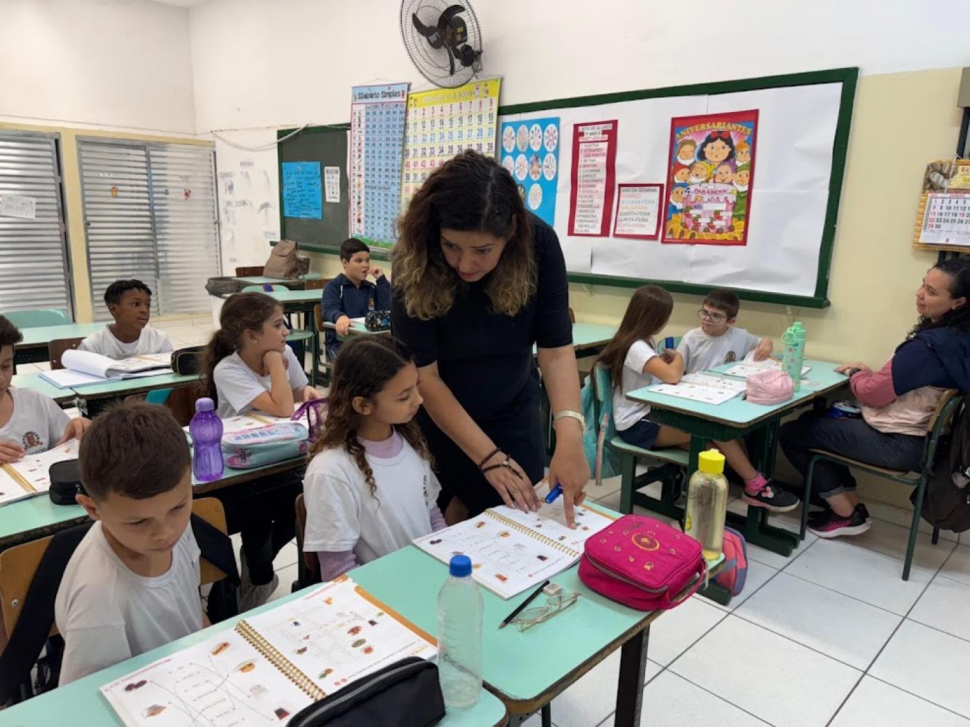 professora ajuda aluna em aula  #paratodosverem