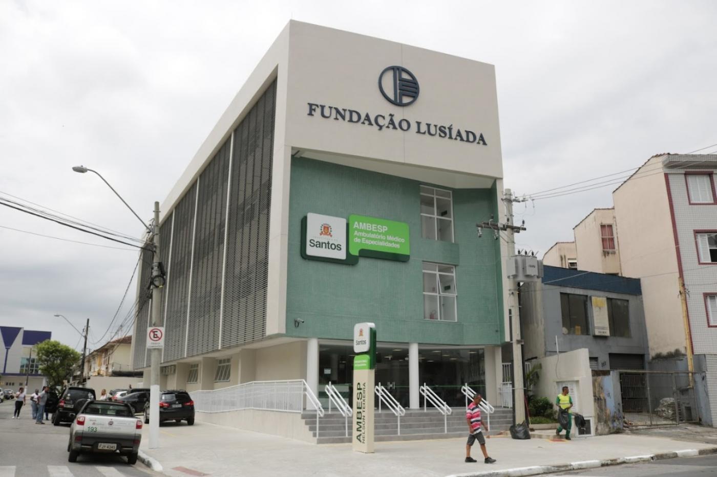 Fachada do ambulatório com pessoas na frente e via ao lado #paratodosverem