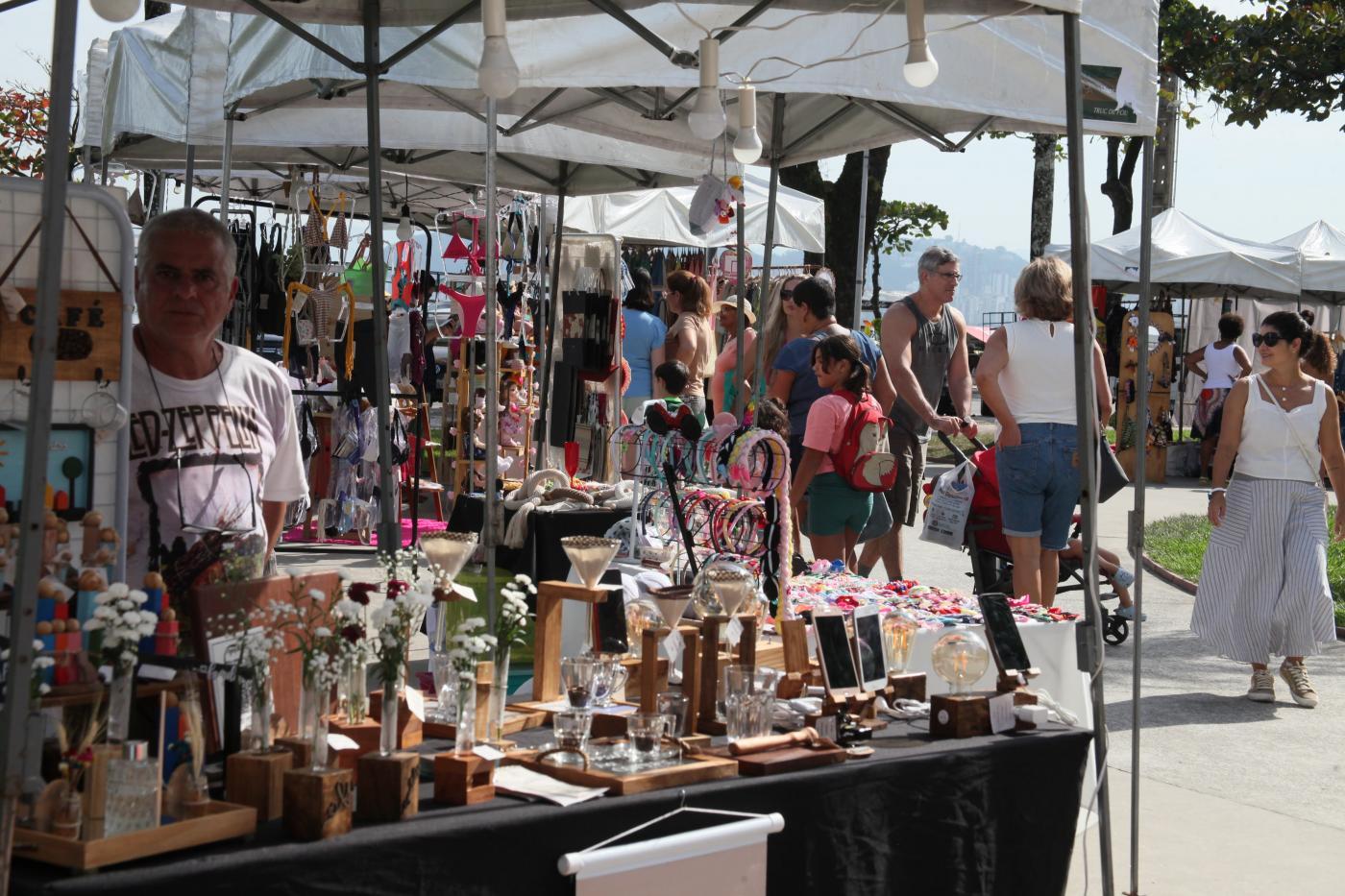 pessoas olham produtos em feira #paratodosverem 