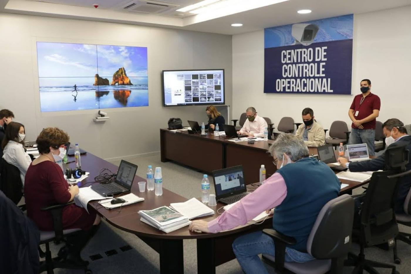 Sala de reunião ocupada por pessoas com máscaras. #Paratodosverem