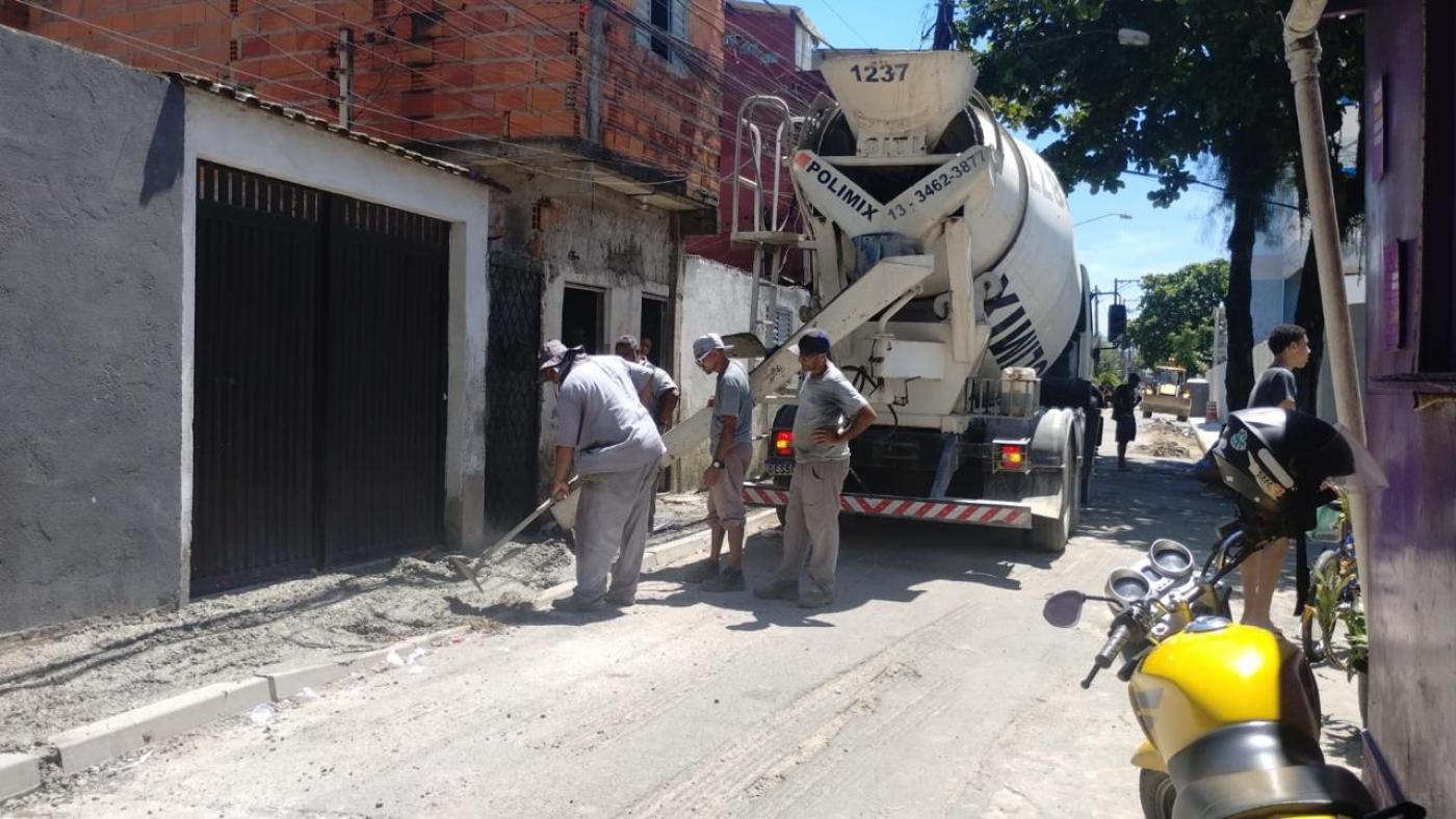 Caminhão está parado em via fazendo a concretagem de calçada do lado esquerdo