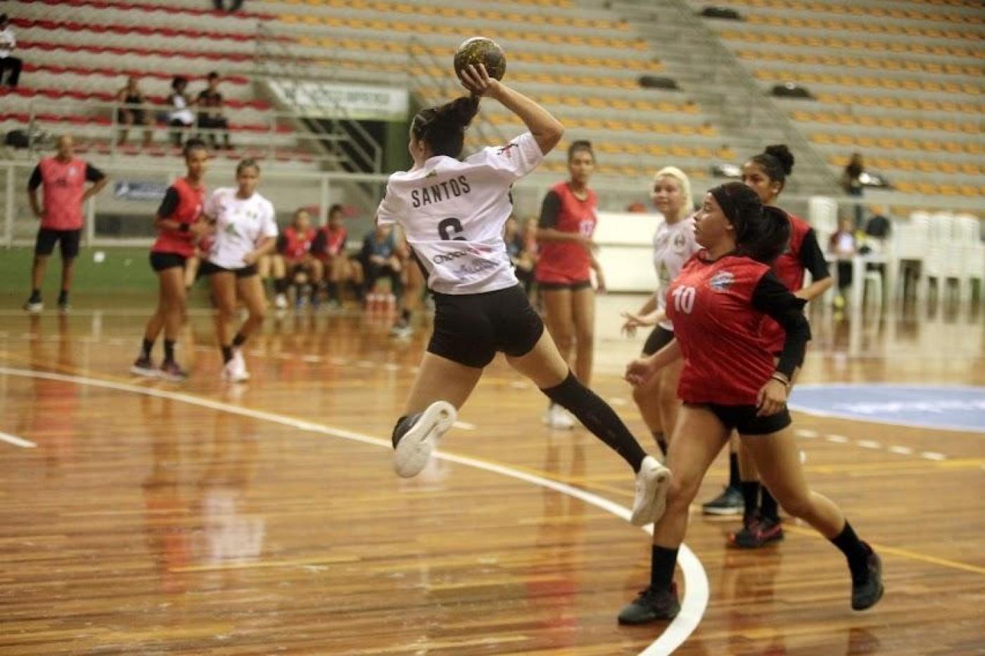 Jogadora pula pra lançar bola no handebol #paratodosverem 