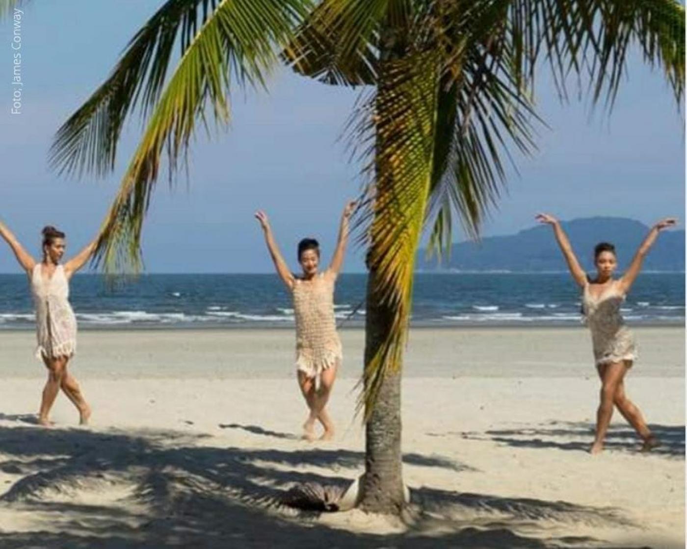 Mulher dançam balé na areia da praia com mar ao fundo #paratodosverem