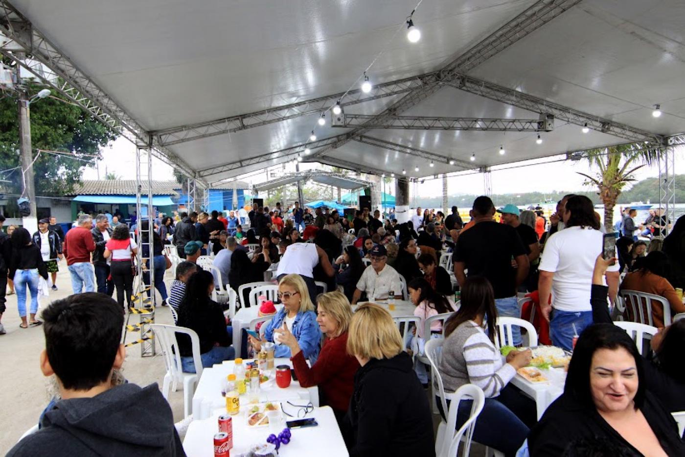 Público ocupa mesas e cadeiras do espaço de alimentação. #pratodosverem